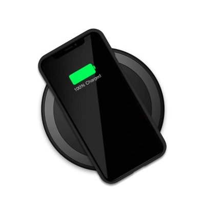 Smartphone preto a carregar num carregador sem fios redondo preto