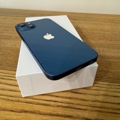 Smartphone Apple iPhone azul escuro sobre caixa branca em superfície de madeira