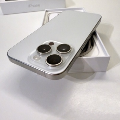 iPhone prateado com três câmaras traseiras preto num fundo branco com embalagem aberta