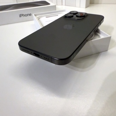 iPhone preto com três câmaras dentro de caixa branca