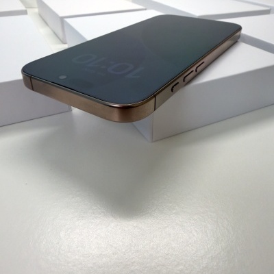 Smartphone dourado com ecrã preto sobre caixas brancas