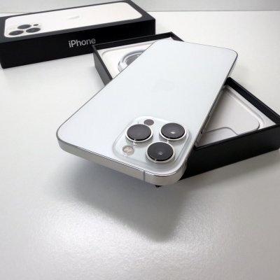Smartphone iPhone branco com três câmaras em embalagem preta