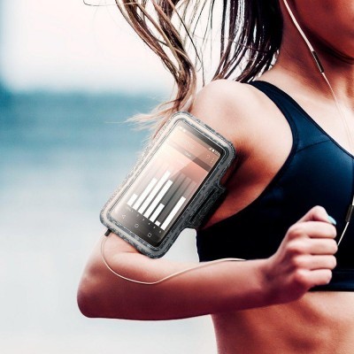 Braçadeira desportiva preta para telemóvel no braço de uma mulher a correr