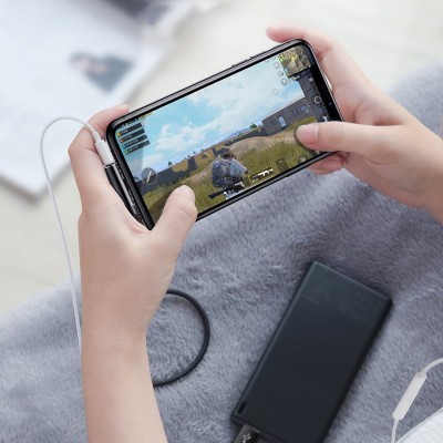 Pessoa a jogar jogo num telemóvel preto ligado a power bank