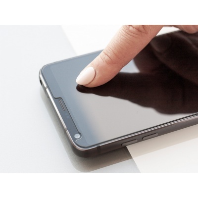 Telemóvel preto com moldura metálica e dedo a tocar no ecrã