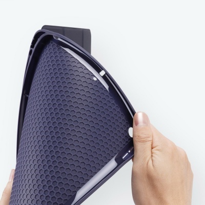 Tapete de silicone preto antiderrapante com padrão hexagonal, sendo dobrado por mãos.