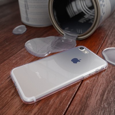 iPhone com capa transparente junto a lata de metal com líquido derramado sobre superfície de madeira