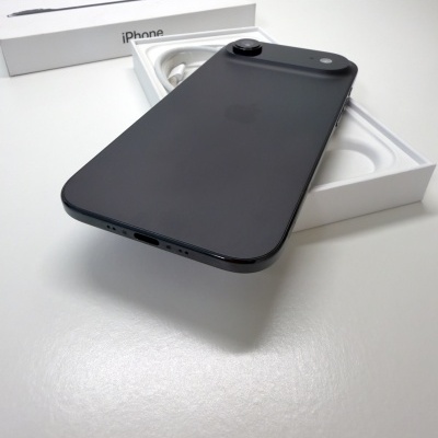 iPhone preto sobre caixa branca com cabo de carregamento