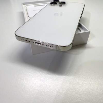 Smartphone Apple iPhone branco com três câmeras traseiras colocado sobre caixa branca