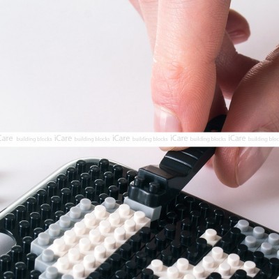 Peças de construção em plástico preto e branco montadas numa base preta