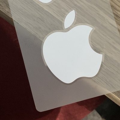 Adesivo com logótipo branco da Apple sobre superfície de madeira