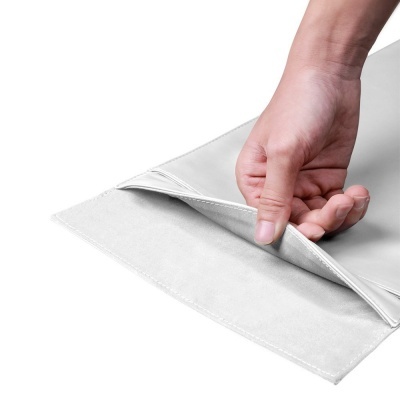 Mão segurando bolsa cinza claro de tecido