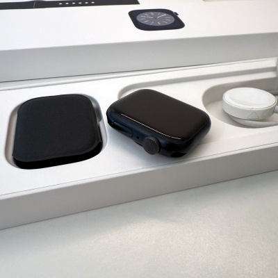 Relógio inteligente preto com acessórios numa caixa branca aberta