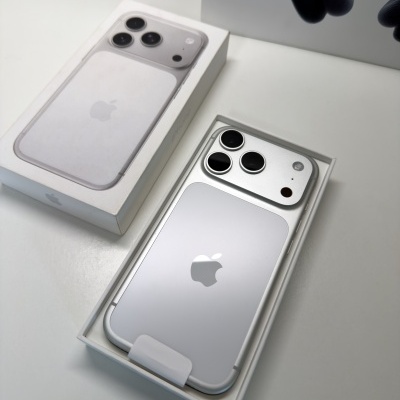 Smartphone Apple iPhone prateado na caixa branca com tampa ao lado.