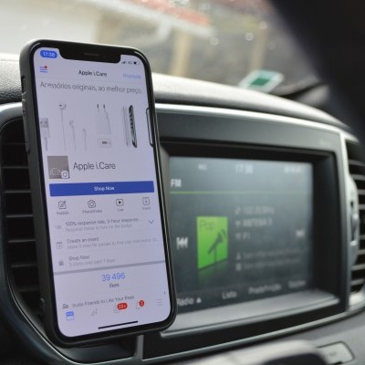 Smartphone a mostrar página Apple iCare no interior de automóvel