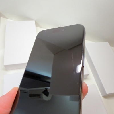 Smartphone preto com ecrã ligado segurado por uma mão
