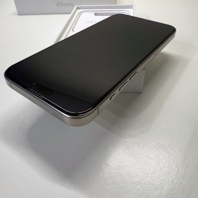 Smartphone iPhone preto com caixa e suporte branco