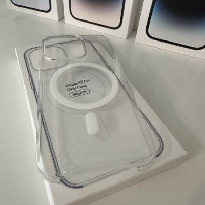 Capa transparente para iPhone 15 Pro com MagSafe sobre caixa branca e três caixas de iPhone ao fundo