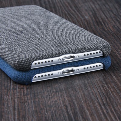 Telemóveis com capas de tecido cinza e azul lado a lado sobre madeira