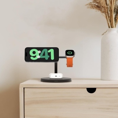 Suporte de carregamento com smartphone, smartwatch e auscultadores sobre móvel de madeira clara