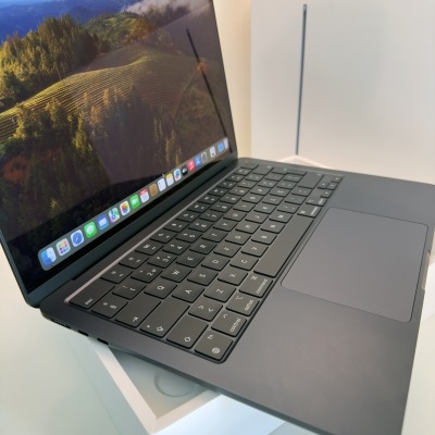 Computador portátil Apple MacBook cinza escuro com ecrã ligado sobre caixa branca