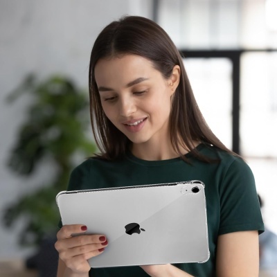 Mulher segurando tablet Apple prateado com capa transparente, fundo interior desfocado