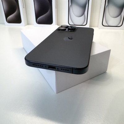 Smartphone preto com três câmaras sobre caixa branca e caixas do mesmo modelo ao fundo