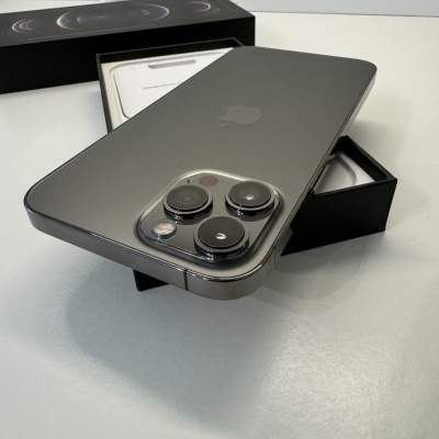 Smartphone preto com três câmaras, caixa preta aberta e caixa branca ao fundo.