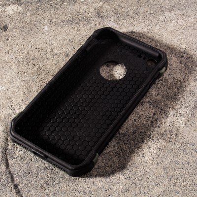 Capa protetora preta para smartphone com textura hexagonal em superfície de concreto