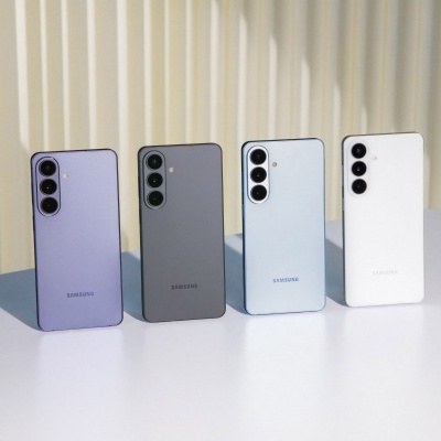 Quatro smartphones Samsung de cores diferentes alinhados sobre uma superfície branca