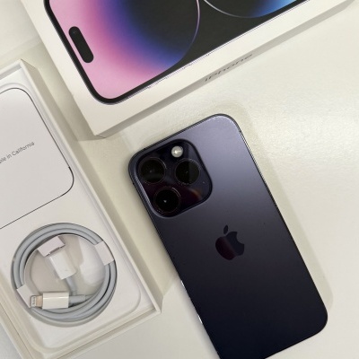 Smartphone Apple iPhone preto com três câmeras e caixa aberta com cabo de carregamento branco