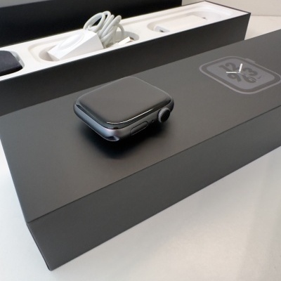 Relógio inteligente Apple Watch preto sobre caixa preta com carregador e cabo USB branco