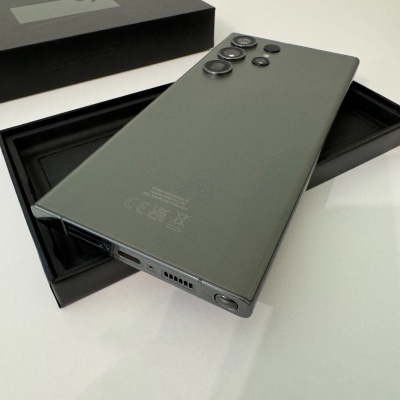 Smartphone cinzento com três câmaras traseiras sobre caixa preta aberta