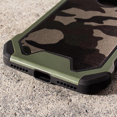 Capa de smartphone verde com padrão camuflado e bordas reforçadas pretas sobre pedra áspera