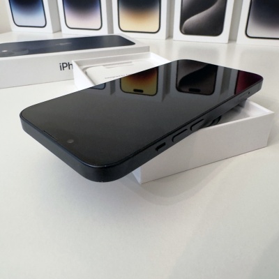 Smartphone preto sobre caixa branca com várias capas ao fundo