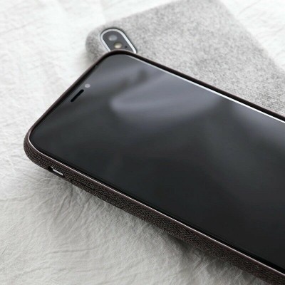 Telemóvel com capa preta e capa cinzenta ao fundo