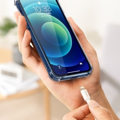 Mãos a segurar smartphone com capa e cabo de carregamento branco