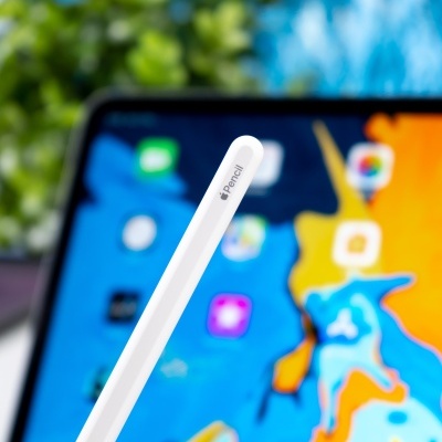 Apple Pencil branca em frente a ecrã colorido de tablet com ícones