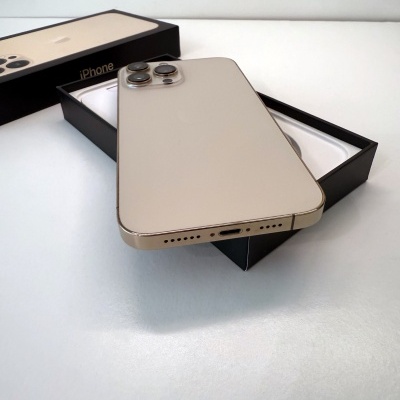 Smartphone iPhone dourado com três câmaras sobre caixa preta com texto iPhone