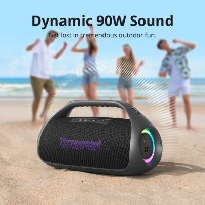 Coluna portátil preta Tronsmart com iluminação colorida na praia e pessoas ao fundo