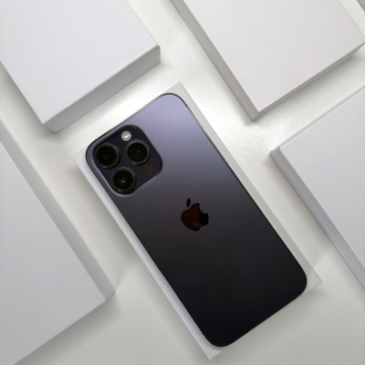 Smartphone Apple iPhone cinza escuro com caixas brancas ao redor.