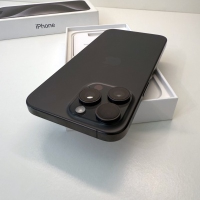 iPhone preto fosco com três câmaras traseiras sobre caixa branca aberta