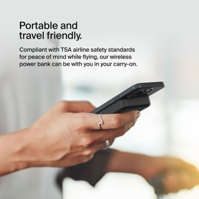 Pessoa segurando smartphone preto com power bank sem fios na parte traseira