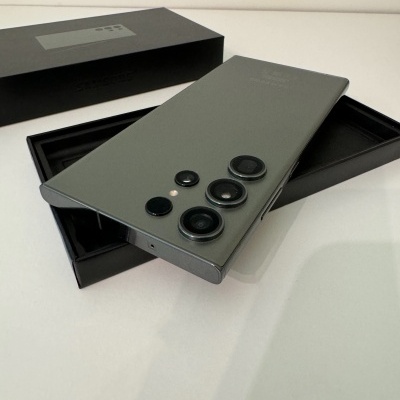 Smartphone cinzento com quatro câmaras traseiras circulares numa caixa preta