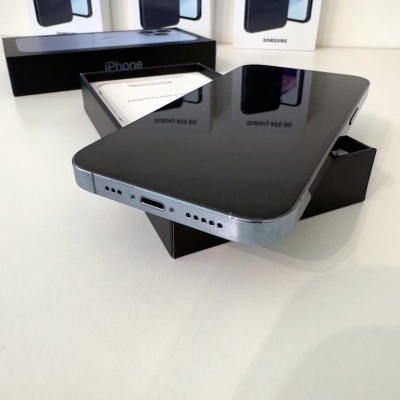 Smartphone preto sobre caixa iPhone com caixas Samsung ao fundo