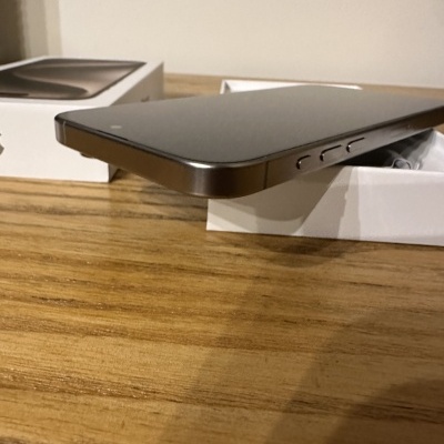 Smartphone prateado com caixa branca sobre mesa de madeira