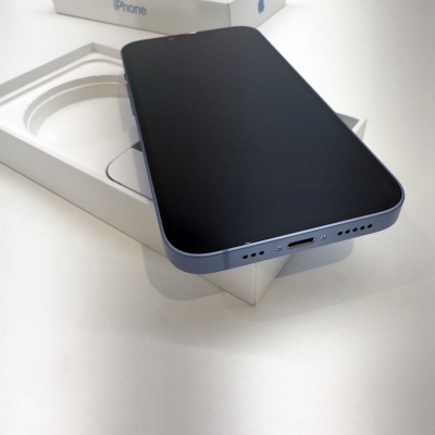 Smartphone iPhone preto dentro de caixa branca com tampa ao fundo