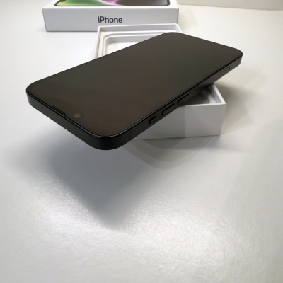 Smartphone preto em caixa branca com texto iPhone numa superfície branca