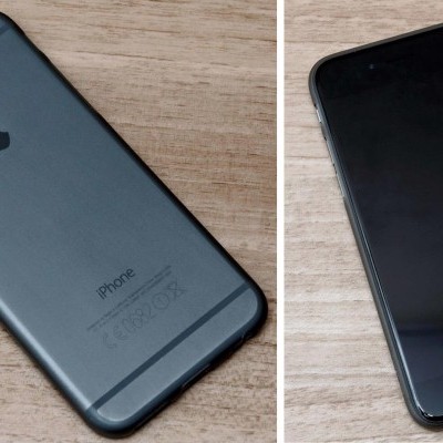 Smartphone iPhone cinzento escuro com ecrã preto em superfície de madeira