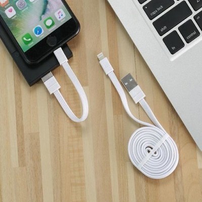 Cabo USB branco com extremidades Lightning e USB, conectado a telemóvel e colocado perto de portátil sobre mesa de madeira